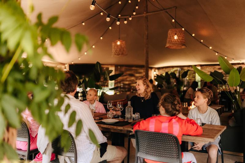 Restaurantbereich der Rancone Lodges mit gedeckten Tischen unter einem lichtdurchfluteten Zeltdach