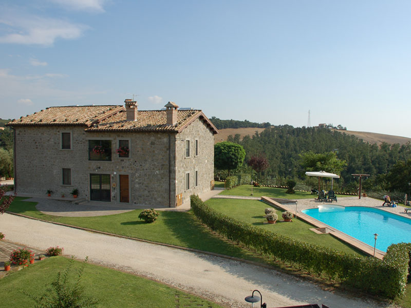 Steinhaus des Agriturismo Casone mit Pool, umgeben von grünen Hügeln bei Montefiascone, Italien